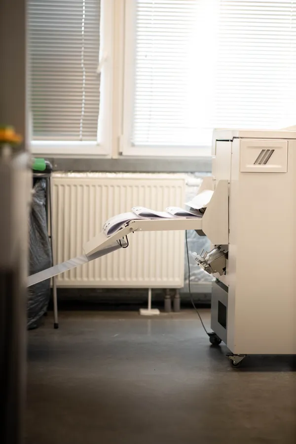 Zautomatyzowany druk i zszywanie instrukcji w jednej linii produkcyjnej - wydajna maszyna drukarska TPi Studio do realizacji folderów i gazetek reklamowych