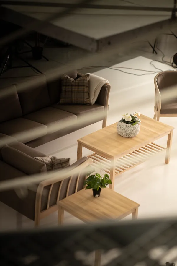 Fragment sceny z sofą na planie zdjęciowym - ujęcie z antresoli pokazujące profesjonalne oświetlenie i przygotowanie do sesji produktowej mebli